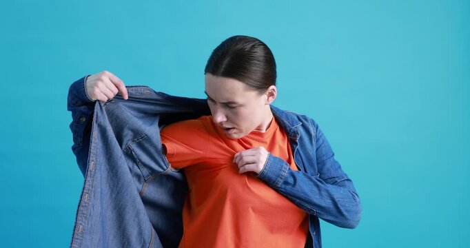 Woman suffering from sweating on light blue background