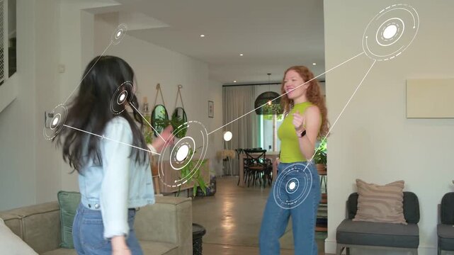 Dark-haired woman stepping and clapping, sparking AR tech rings around two friends dancing in home