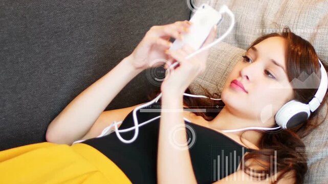 Woman reclining on couch raising phone, tapping screen and bringing up HUD graphics for app testing