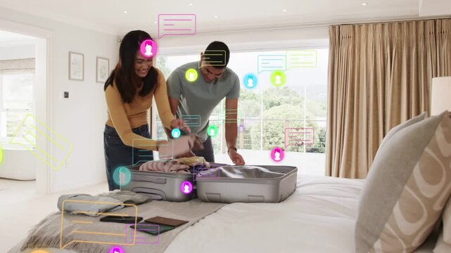 Man and woman opening suitcase and packing clothes on bed for travel, smartphone causing AR icons