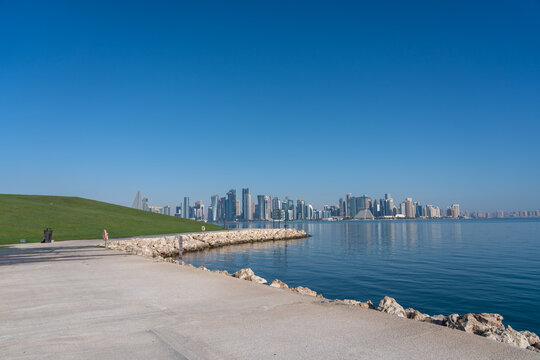 Doha MIA Park Promenade with Grassy Mound West Bay Skyline and Walker