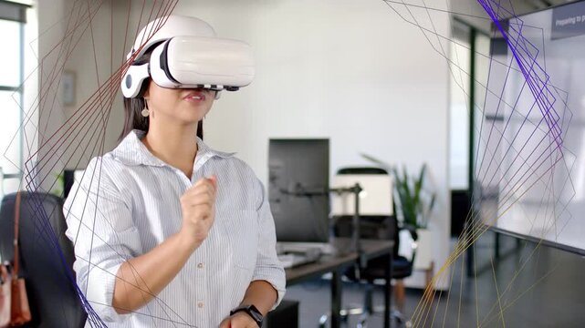 Woman in office wearing VR headset, extending right hand, activating wireframe HUD for tech control