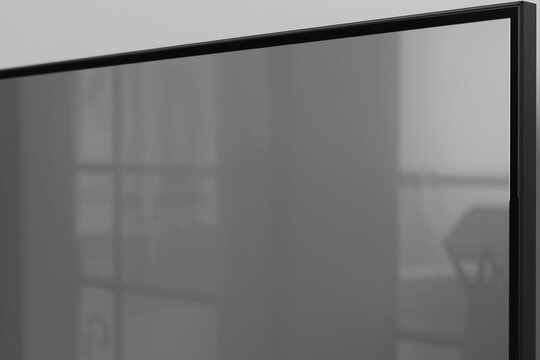 a blank television screen with a sleek black bezel and a subtle sheen, the screen itself is a dull grey flat surface with no image,