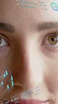 Vertical video: Woman eyes opening shifting gaze in finance shot activating HUD charts for trading