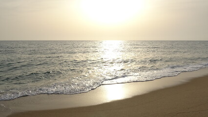 Obraz premium Bright Morning Sun Reflecting on the Calm Ocean Surface. A stunning sunrise view where the bright morning sun shines over the horizon, creating a shimmering golden path on the East Sea waves.