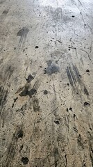 Fototapeta premium Grungy concrete surface with weathered textures and dark smudges, an abstract industrial background