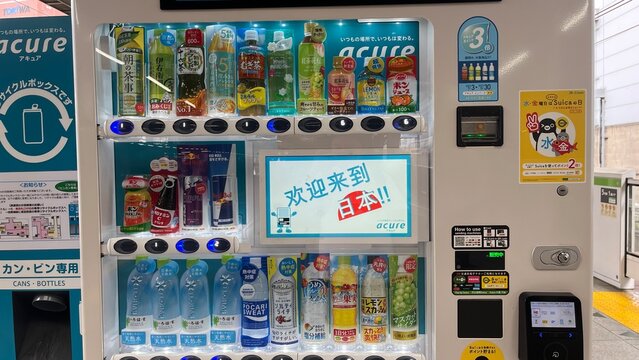 Modern Acure digital beverage vending machine with welcome message and assorted Japanese bottled drinks at JR East station platform - Tokyo, Kanto, Japan, September 10, 2023
