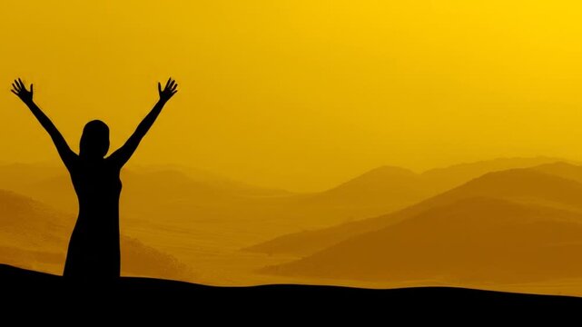 Silhouette of person with arms raised against yellow landscape