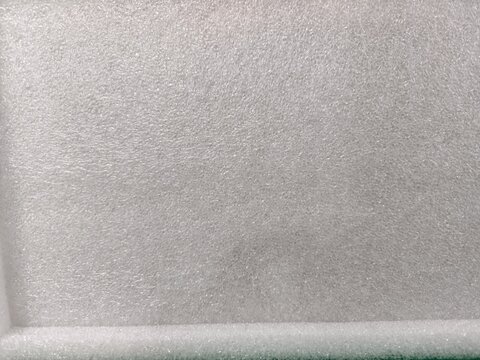 Close-up of a white, textured foam surface, showcasing its soft and porous material.