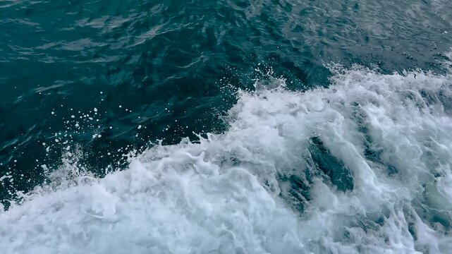 Close up of the side wake created by a moving passenger ferry on the Marmara Sea in Istanbul, showing strong lateral waves and dense white foam along the hull