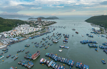 A vast fleet of colorful fishing boats are anchored in the harbor in Nha Trang, Vietnam, showcasing the city's vibrant maritime industry. © Zenstratus