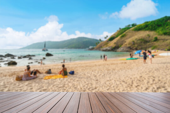 Beautiful beach view from a wooden terrace, tourists relaxing on the white sand beach under a blue sky on summer vacation