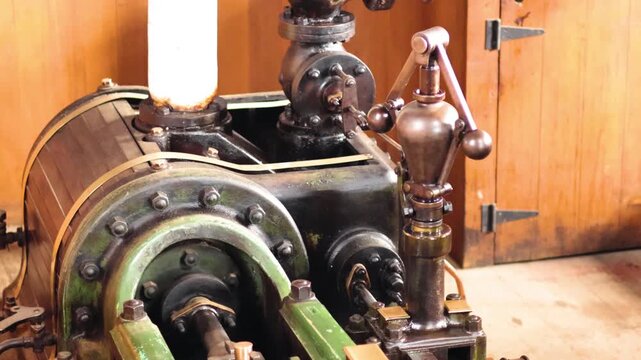 Vintage steam engine powering historical machinery in a rustic wooden workshop motion.