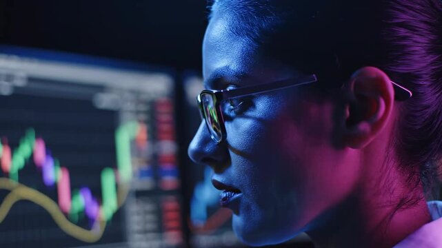 Focused Female Trader Analyzing Stock Market Charts on Multiple Monitors in a Dark Room with Neon Lighting for Financial Technology and Investment Banking Concepts.