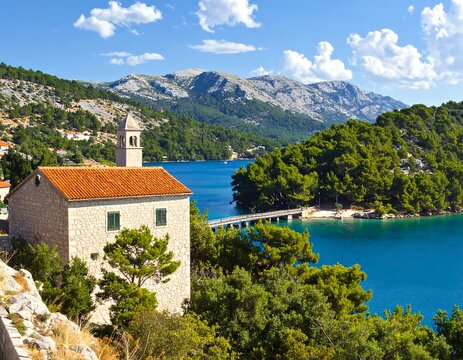 A serene landscape of a small stone church by a tranquil turquoise sea