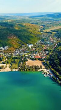 Vertical video. Abrau-Diurso, Krasnodar Krai, Russia. Lake Abrau, the largest freshwater lake in the North-West Caucasus, Drone footage over emerald water and forested hills. Drone footage. Rich colo