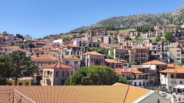 Arachova village at Parnassus, Greece. Famous winter sports destination and ski resort with traditional stone houses and alpine scenery. Picturesque mountain town view under a clear summer sky.