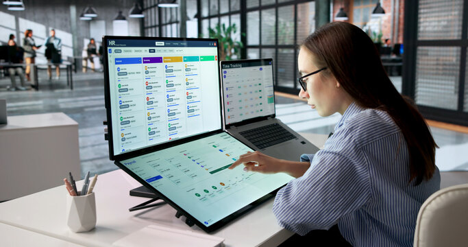 Woman Reviewing Payroll System On Laptop