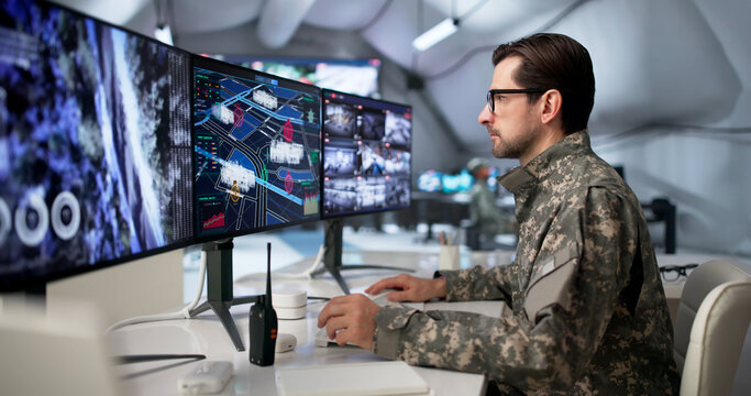 Military Officer Studies Data On Computer Desk