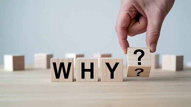 Asking why concept with hand placing question mark and wooden blocks showing curiosity and thinking