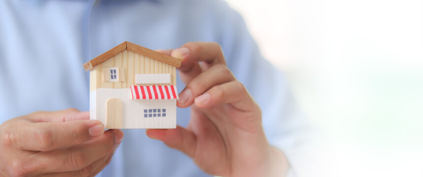 Businessman's hand chooses wooden toy franchise store for goal to growth is investment planning financial and branch expansion and management bank loans for marketing franchising.