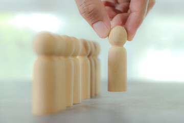 Hand choose wooden person stands for HR human resources personal leader training skill or leadership and challenge business team player and organization management teamwork. © Jintana