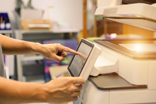 Office men use photocopy or copier machine at workplace is equipment for make a copy paper or photocopier for scanning document and photocopying service maintenance concepts.