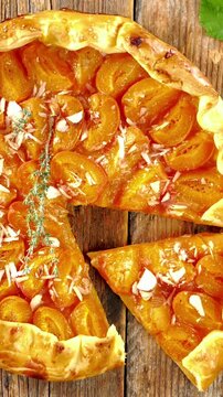 homemade rustic apricot galette with almond flakes on wooden background, sweet fruit tart with golden crispy crust