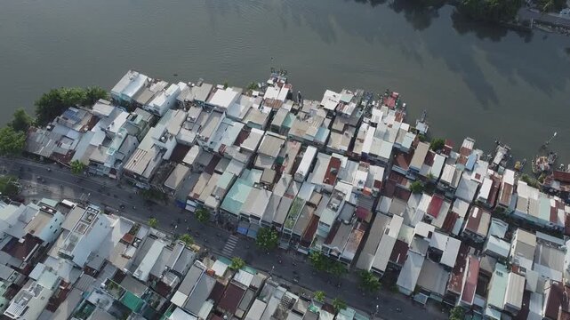 Aerial view of small boats and shanty houses along Doi canal in District 8, tilting up to Ngo Gia Tu school and Vo Van Kiet boulevard, Ho Chi Minh City, Vietnam