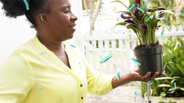 woman holding pot at arm, moving plant closer for garden with blue pluses floating over pot
