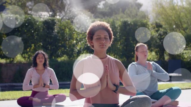 Center yoga lead raising arms urging group lowering prayer breathing mudras for calm bokeh drifting