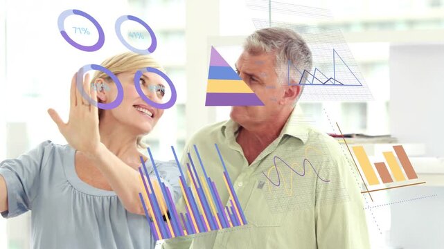 Woman gesturing at glass, making rings and bars visible, man pointing and sorting data for business