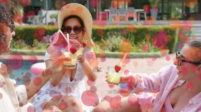 Three women clinking drinks at pool, sparking bokeh obscuring then revealing float ring marketing