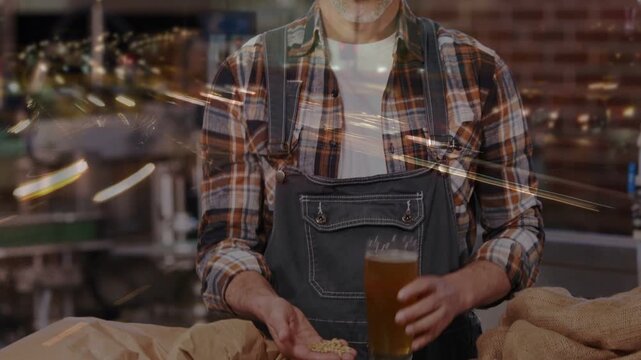 From sacks spilling brewer handling grains, inspecting pint for tasting in brewery with bokeh