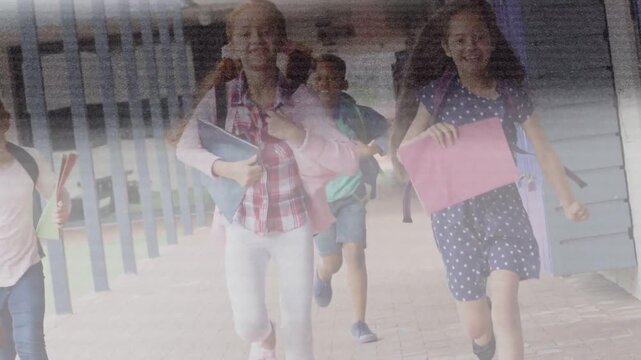 Students running toward camera along school walkway, bell ringing, folders and backpacks flying