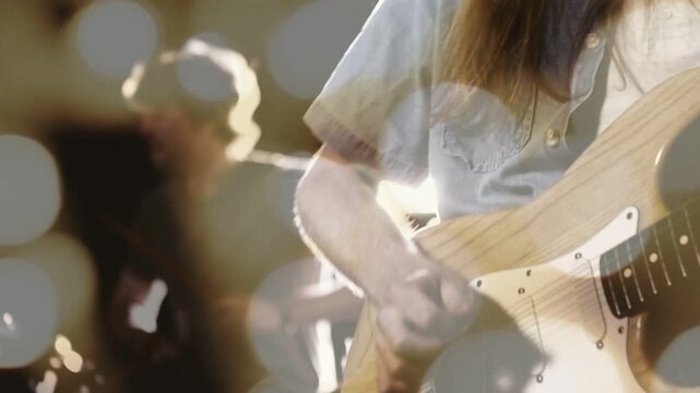 Guitarist playing guitar on stage, causing pullback revealing drummer, bokeh boosting music