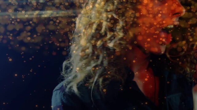 Lead singer performing, gripping mic, starting vocal, causing particle overlay, cam pulling back
