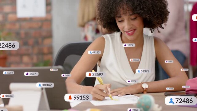Woman marking designs at desk, tablet pinging alert badges peaking then fading showing engagement