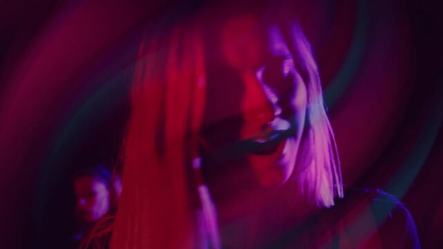 Woman singing shifting gaze in studio light cue starting neon light trails sweeping face for music