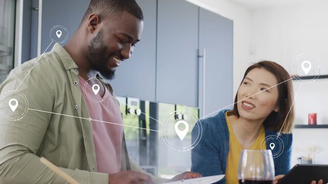 Couple cooking at kitchen counter, consulting tablet and creating location-pin links overlay