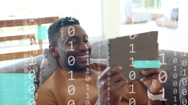 Mid-adult man tapping tablet causing binary teal blocks covering tablet and face, viewing tech feed