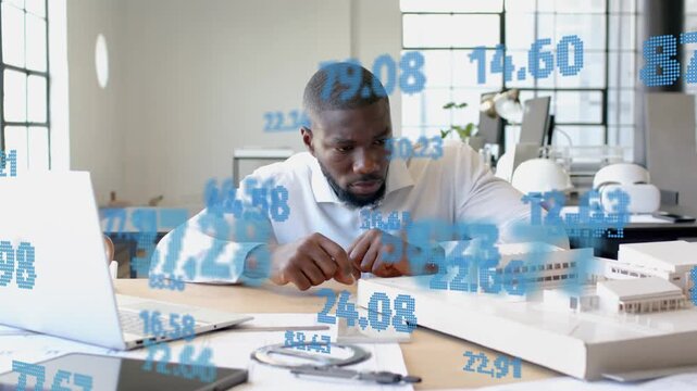 Designer checking watch, adjusting scale model for design review, blue numbers overlaying scene