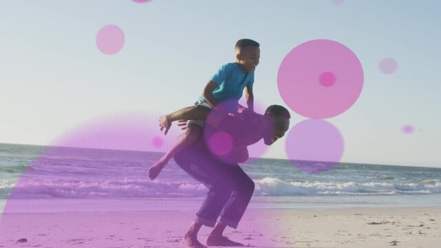 Son running to dad on shore, jumping on back, dad lifting pink-purple bubbles growing around family