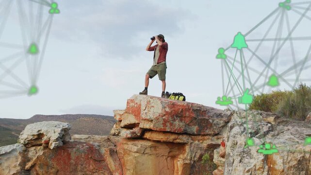 Widening shot man using binoculars scanning horizon for route as tech net over ledge drifting