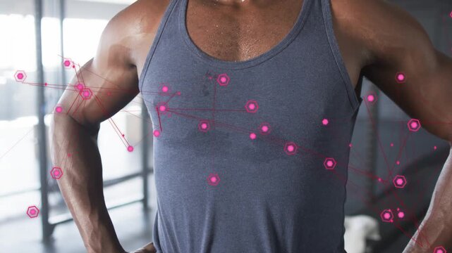 Male trainee panting post-workout in gym, wearing towel and wristband, pink AR nodes tracking chest