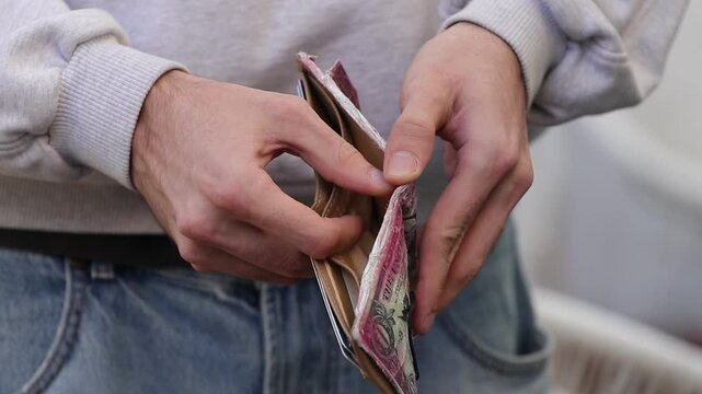 young hand opening empty wallet