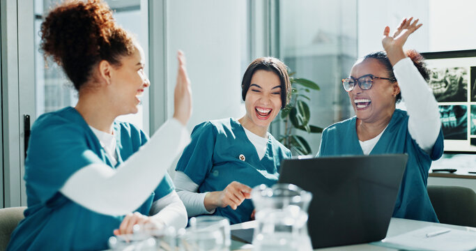 Happy women, nurse and celebration with high five for teamwork, winning or success in hospital. Female people, healthcare workers or group with laptop or smile for good news or achievement in clinic