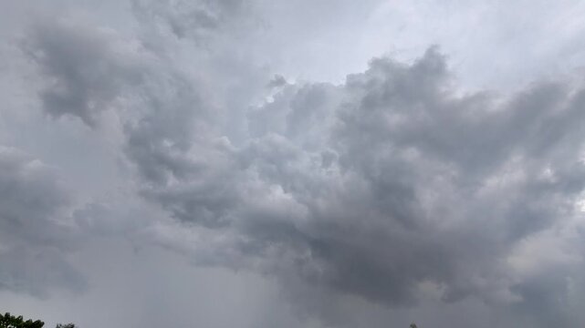 Dramatic time-lapse of thick gray storm clouds moving across the sky. Overcast atmosphere before heavy rain