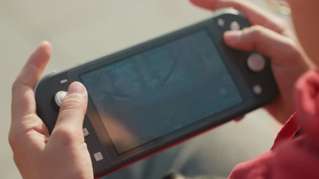 Closeup hands navigating map on console screen, strategic gameplay and exploration, outdoor light on red jacket, player studying route and waypoints with steady thumbs and engaged focus.