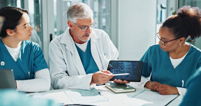 Doctor, nurses and x ray in hospital with tablet screen, discussion or medical research for diagnosis. Healthcare worker, people and brainstorming with tech, bones scan or explain idea for case study